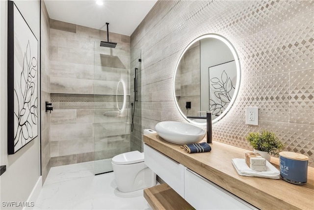 bathroom with walk in shower, vanity, toilet, and tile walls