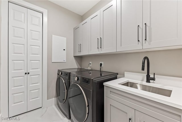 laundry room with cabinets, independent washer and dryer, electric panel, and sink