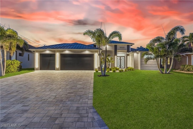 view of front of property featuring a yard and a garage