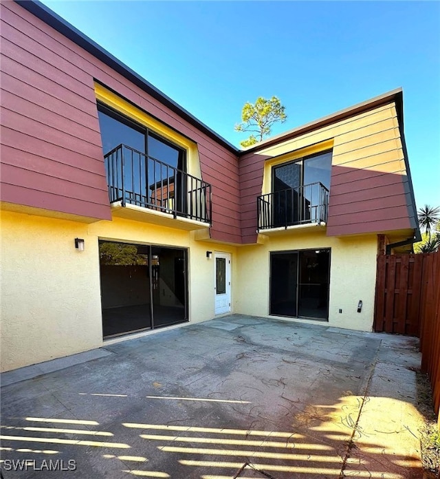 rear view of house with a balcony and a patio