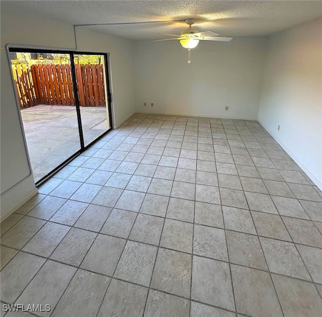 tiled spare room with ceiling fan and a textured ceiling