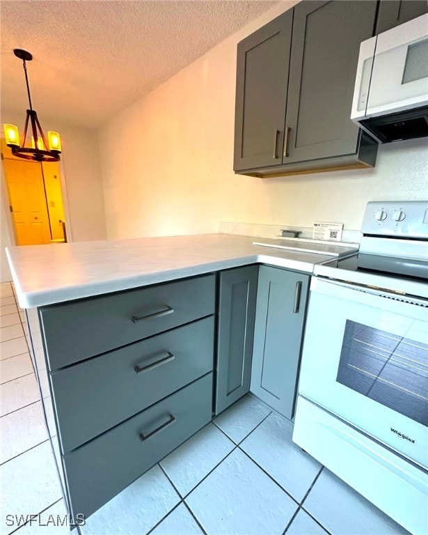 kitchen featuring pendant lighting, light tile patterned floors, white appliances, gray cabinetry, and a textured ceiling