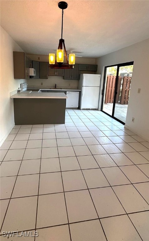 kitchen featuring white appliances, dark brown cabinetry, kitchen peninsula, and light tile patterned floors