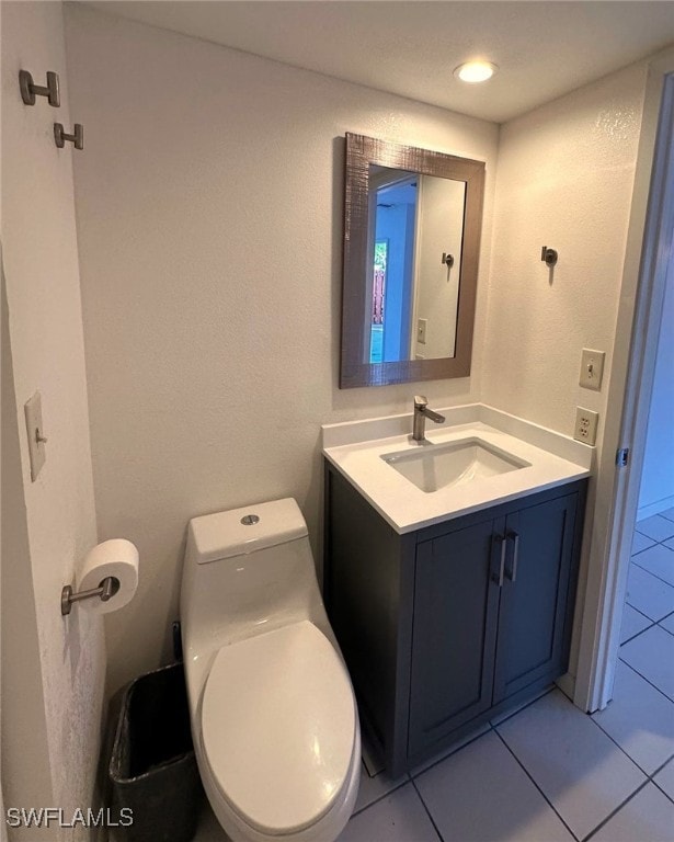 bathroom featuring vanity, tile patterned floors, and toilet