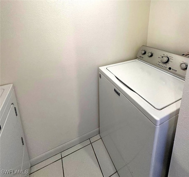 clothes washing area featuring washer / clothes dryer and tile patterned floors