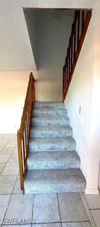 stairs with a textured ceiling