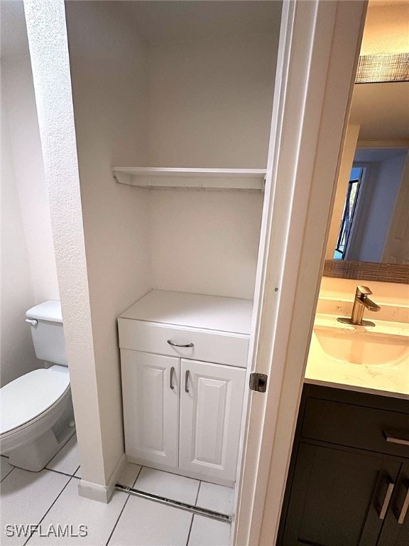 bathroom with tile patterned flooring, vanity, and toilet