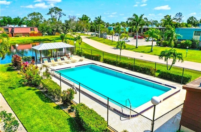 view of swimming pool with a yard, a gazebo, a patio area, and a water view