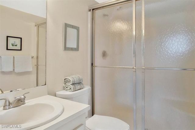 bathroom featuring vanity, toilet, and walk in shower