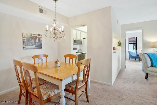 carpeted dining room with a chandelier