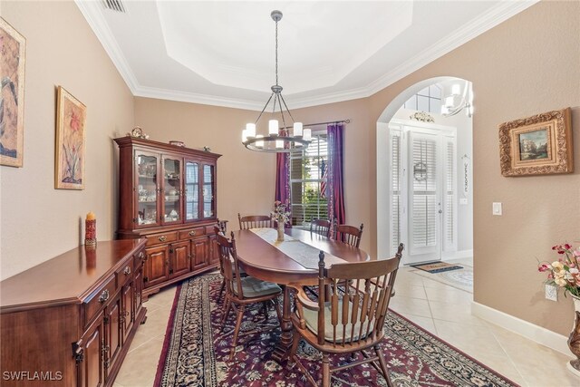5683 Whispering Willow Way, Fort Myers, FL 33908 - dining area with a chandelier, arched walkways, light tile patterned floors, a tray ceiling, and crown molding