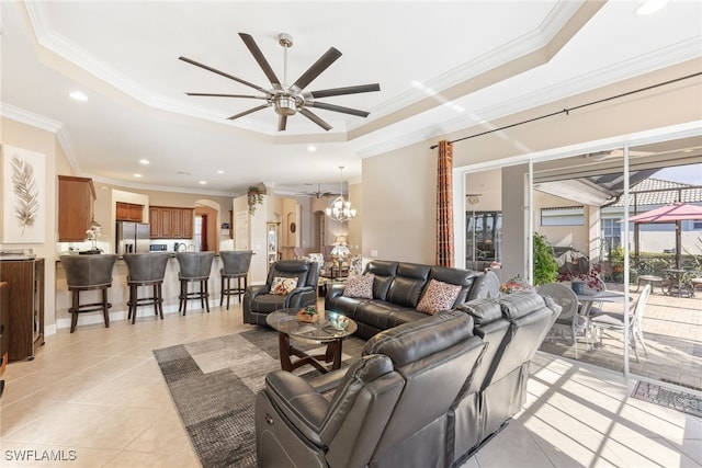 5683 Whispering Willow Way, Fort Myers, FL 33908 - living room with a tray ceiling, a ceiling fan, crown molding, light tile patterned floors, and a chandelier