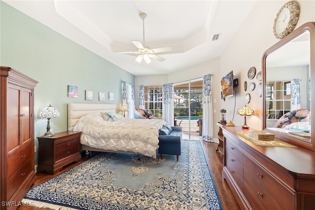 5683 Whispering Willow Way, Fort Myers, FL 33908 - bedroom featuring dark wood-style flooring, access to exterior, a raised ceiling, and a ceiling fan