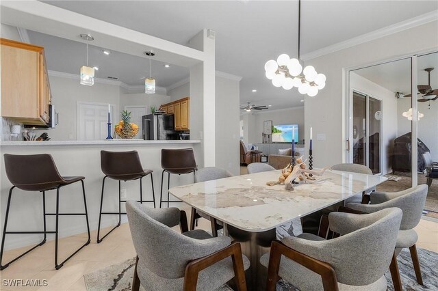 tiled dining space featuring crown molding and ceiling fan