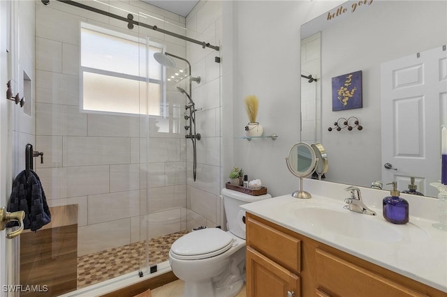 bathroom featuring vanity, toilet, and a shower with door