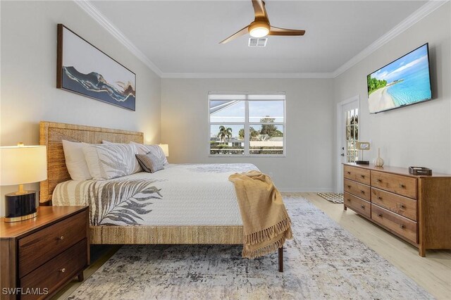 bedroom featuring ornamental molding, ceiling fan, and light wood-type flooring