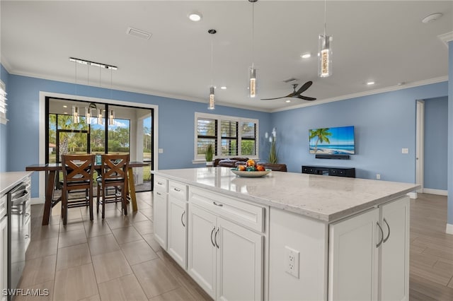 kitchen featuring ornamental molding, a kitchen island, pendant lighting, and white cabinets