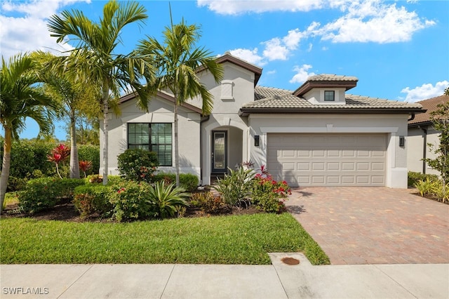 mediterranean / spanish home featuring a garage and a front yard