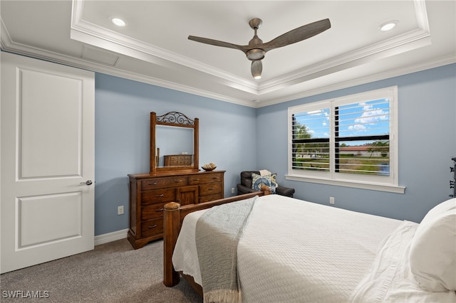 carpeted bedroom featuring crown molding and a tray ceiling