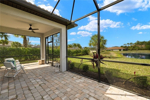 unfurnished sunroom featuring a water view and ceiling fan