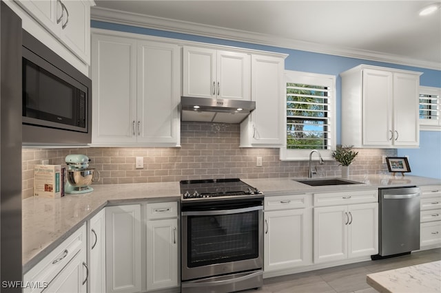 kitchen with stainless steel appliances, white cabinetry, sink, and light stone counters