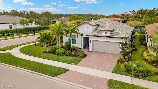 mediterranean / spanish-style home featuring a garage and a front yard