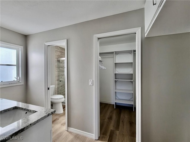 bathroom with vanity, hardwood / wood-style floors, toilet, and walk in shower