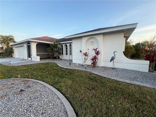 ranch-style home featuring a garage and a front lawn