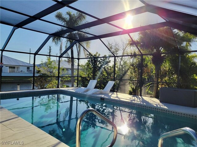 view of pool with glass enclosure and a patio area