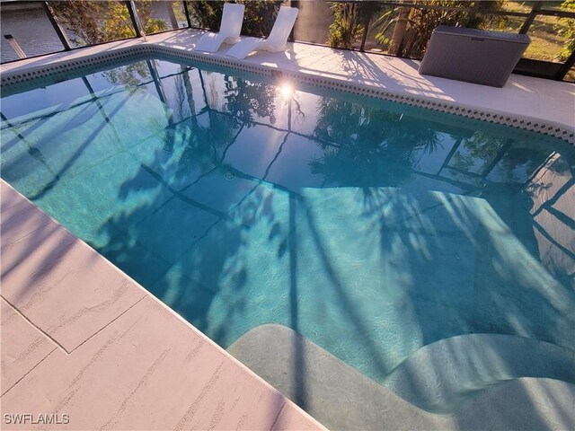 view of swimming pool featuring a lanai