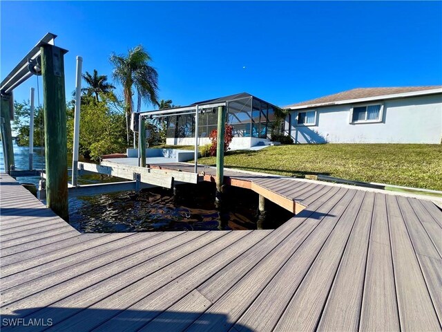 view of dock with a yard and glass enclosure