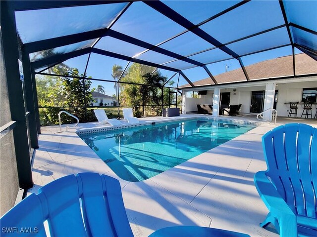 view of pool featuring a patio area and glass enclosure