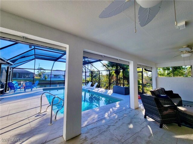 view of pool featuring a patio area, ceiling fan, and glass enclosure