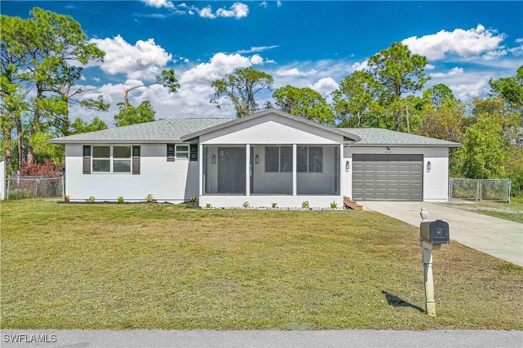 single story home featuring a garage, a front lawn, and a sunroom