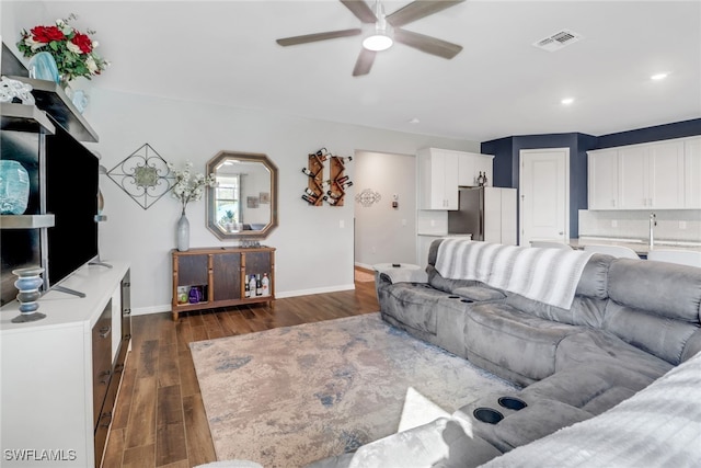 living room with ceiling fan and dark hardwood / wood-style floors