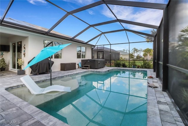 view of swimming pool with a hot tub, a patio, and glass enclosure