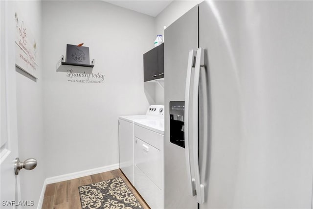 laundry area featuring cabinets, independent washer and dryer, and light wood-type flooring