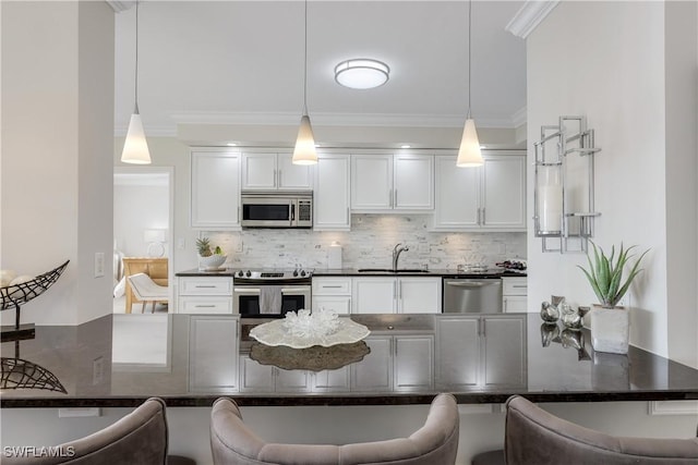 kitchen with pendant lighting, appliances with stainless steel finishes, and a breakfast bar area