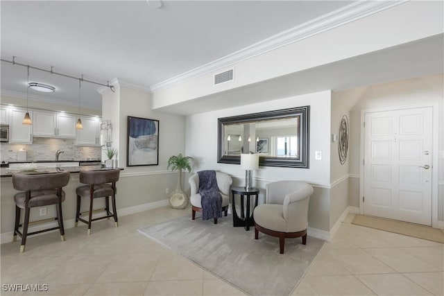 sitting room featuring ornamental molding and light tile patterned flooring