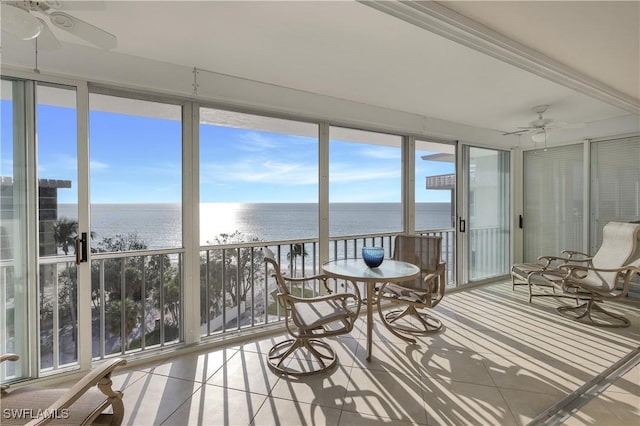 unfurnished sunroom with a water view and ceiling fan