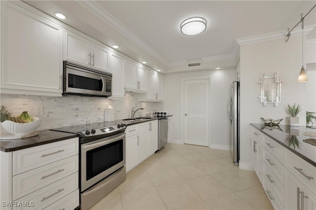 kitchen with sink, crown molding, appliances with stainless steel finishes, pendant lighting, and white cabinets