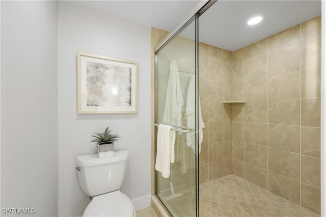 bathroom with a shower with door and toilet