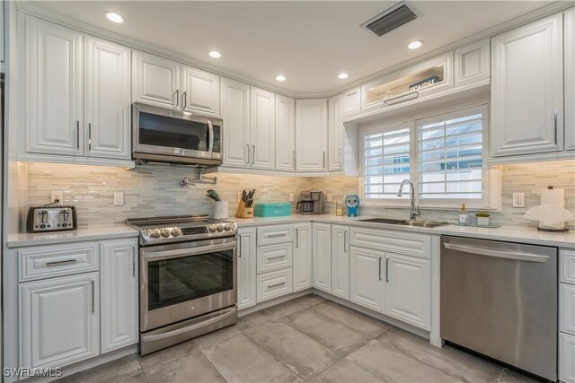 kitchen featuring sink, white cabinets, and appliances with stainless steel finishes