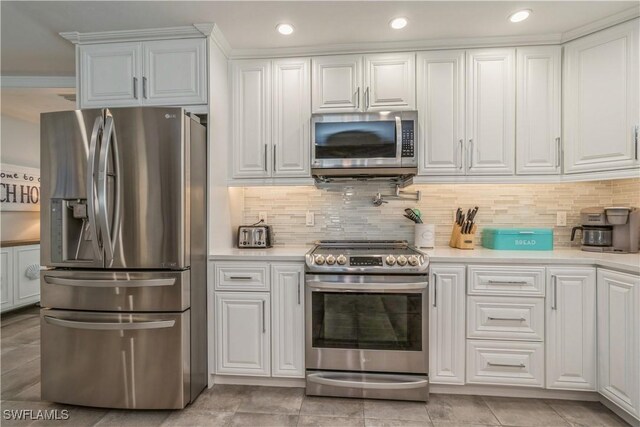 kitchen with white cabinetry, stainless steel appliances, and decorative backsplash