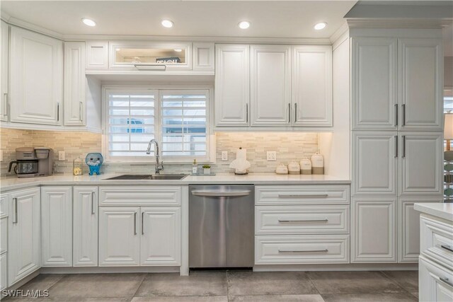 kitchen with white cabinetry, dishwasher, sink, and decorative backsplash