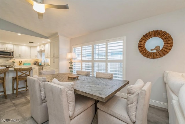 dining area featuring sink, vaulted ceiling, and ceiling fan