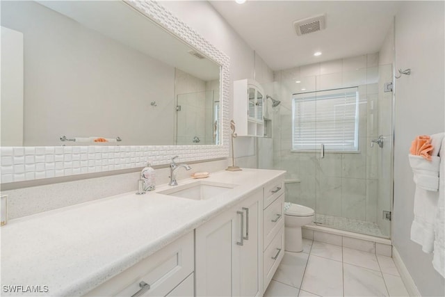 bathroom featuring vanity, toilet, tile patterned flooring, and a shower with door