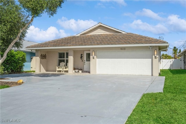 ranch-style home featuring a garage and a front lawn