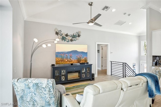 living room with crown molding and ceiling fan