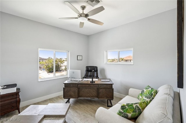 home office with ceiling fan and light hardwood / wood-style flooring